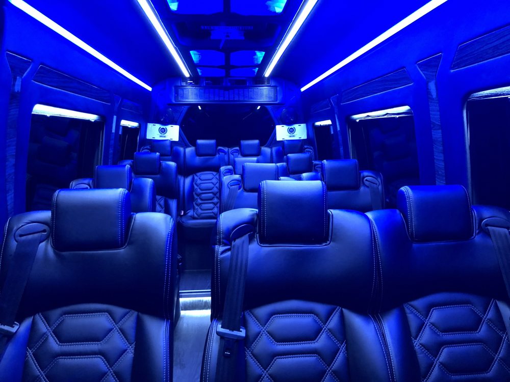 Blue-lit leather seating inside a party bus