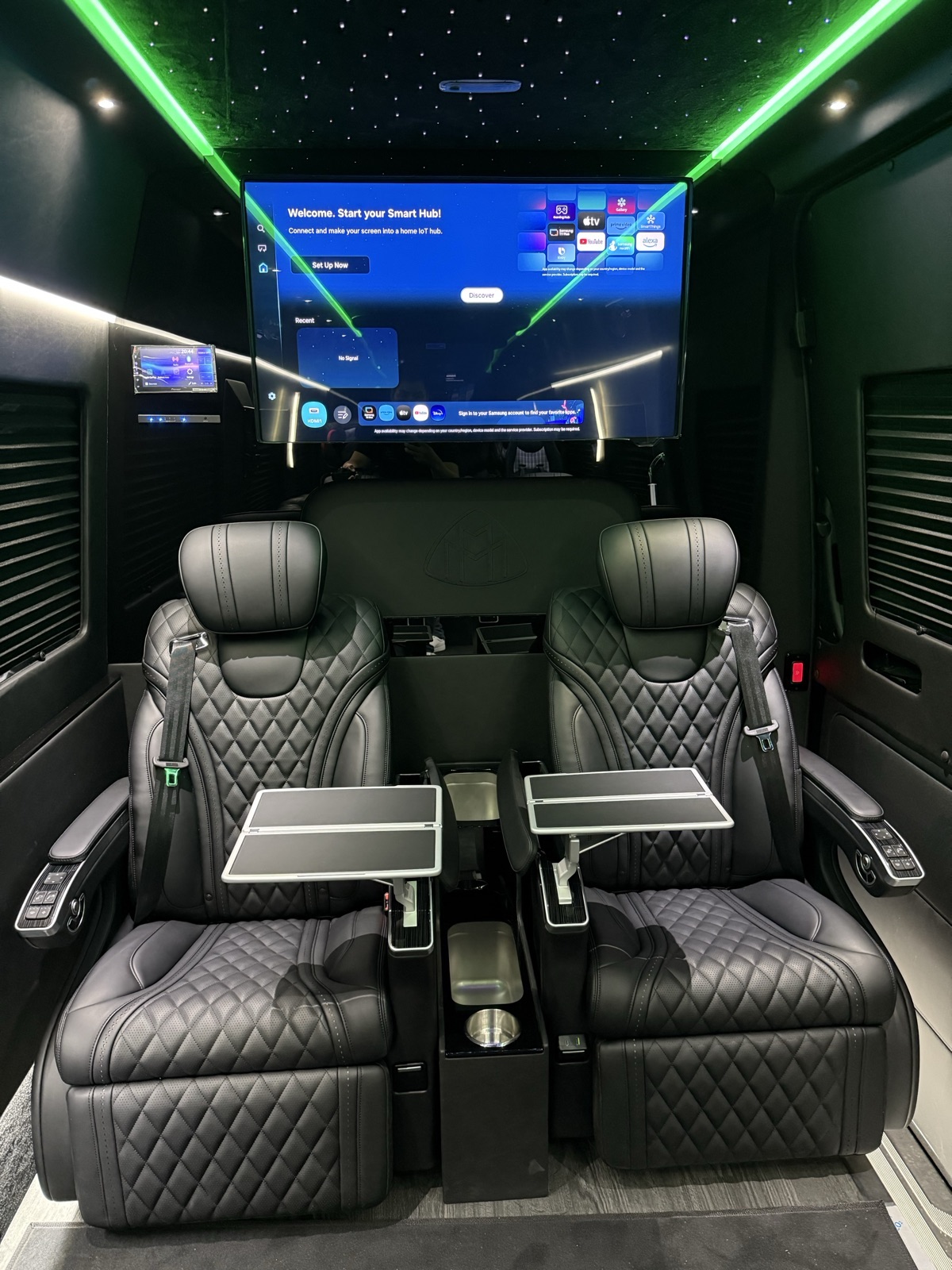 VIP Sprinter cabin with captain chairs, fold-out tables and a large TV