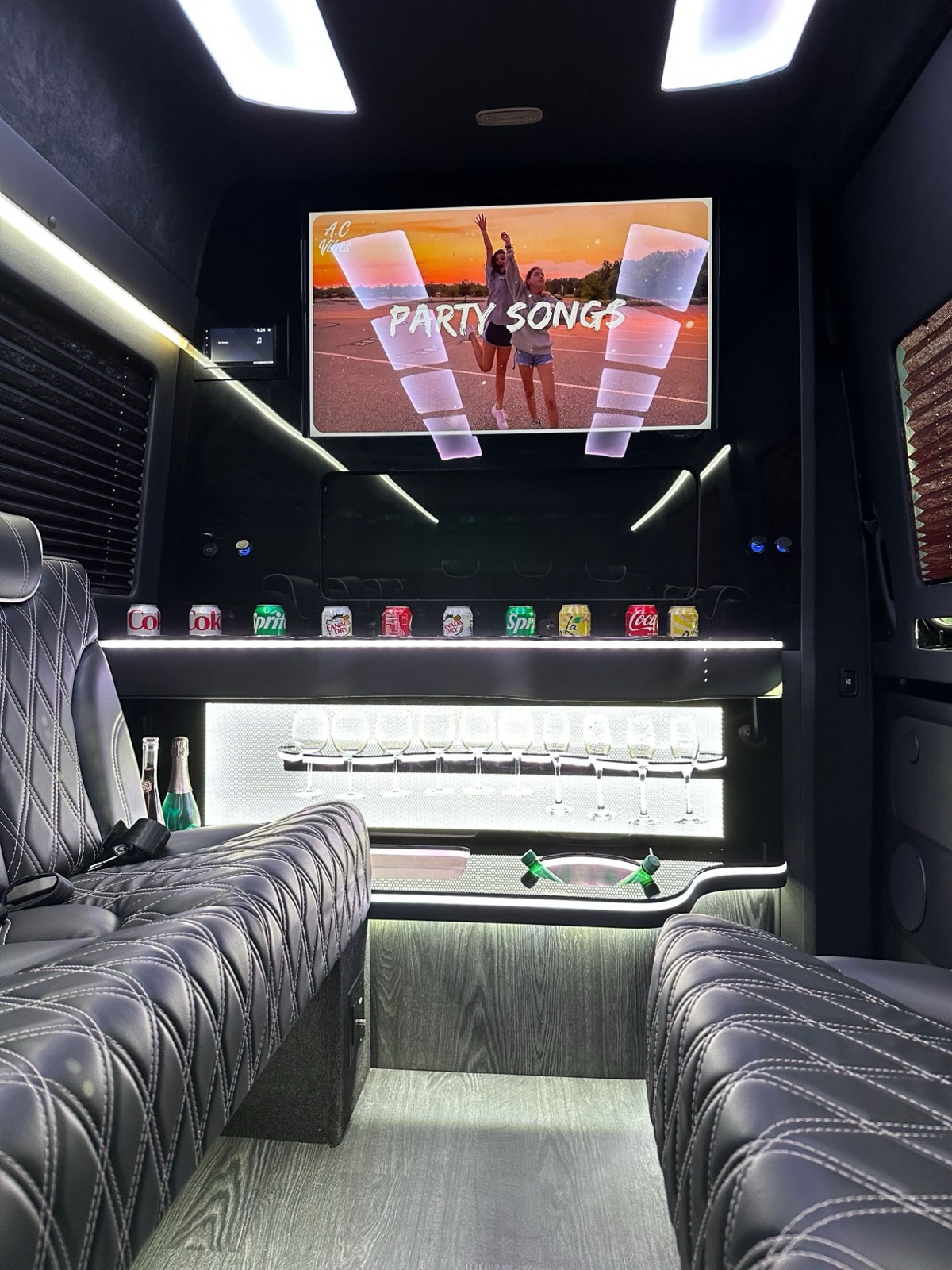 VIP Sprinter party cabin with TV, bar lighting and leather bench seats